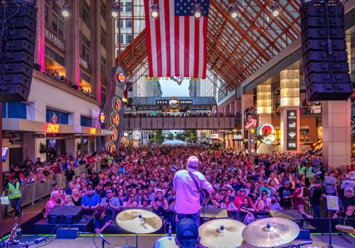 The view from behind the drums as a singer plays his guitar to a packed concert crowd at Fourth Street Live!